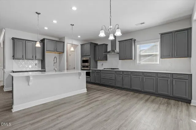 a large kitchen with granite countertop a large counter top space appliances and cabinets