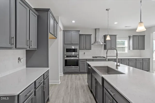 a kitchen with stainless steel appliances granite countertop a sink a stove and a refrigerator