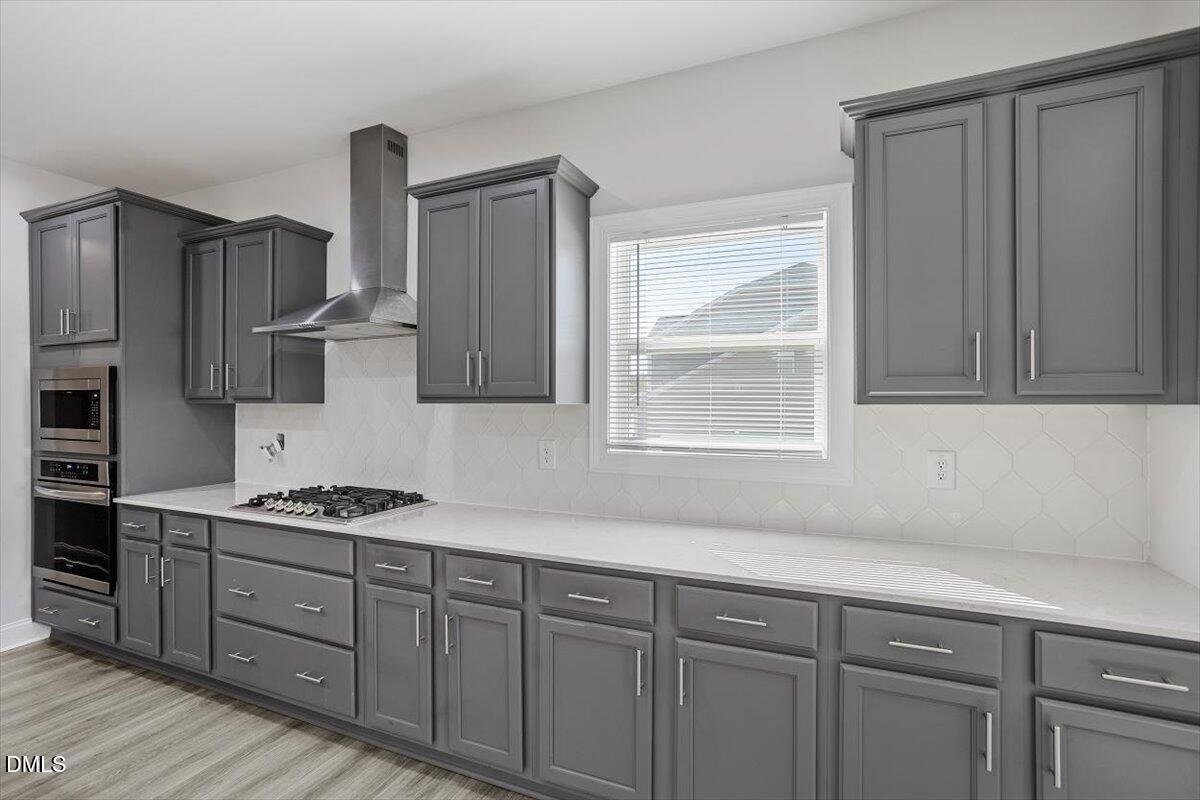 114 Stephens Timberline View Clayton, NC 27520 - Photo 22 of 43 a kitchen with stainless steel appliances granite countertop a sink a stove cabinets and wooden floor