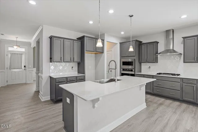 a kitchen with stainless steel appliances kitchen island a refrigerator sink and cabinets