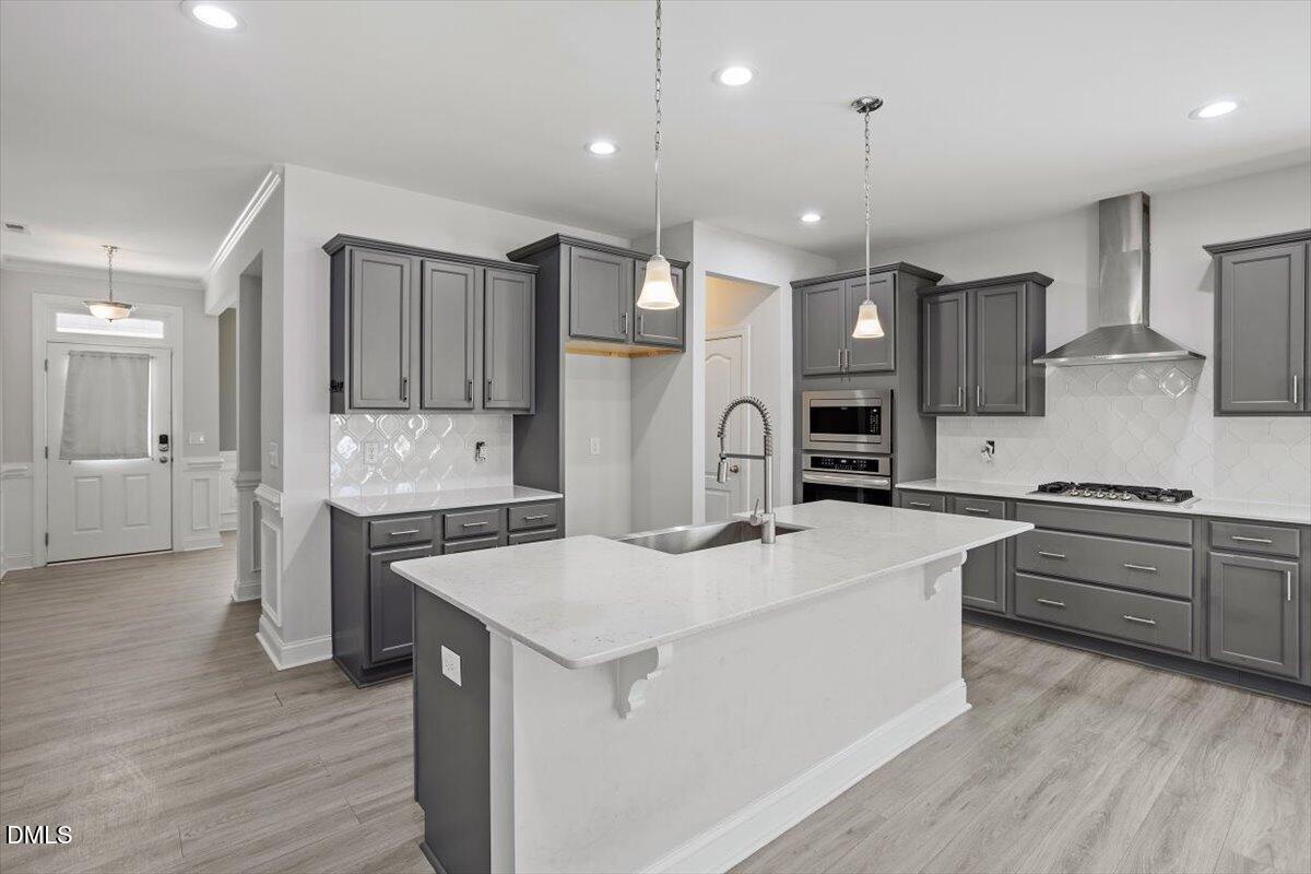 114 Stephens Timberline View Clayton, NC 27520 - Photo 24 of 43 a kitchen with stainless steel appliances kitchen island a refrigerator sink and cabinets