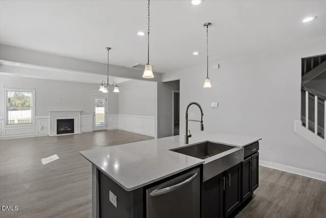 a kitchen with kitchen island a sink appliances and a wooden floor