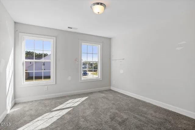 an empty room with windows and closet