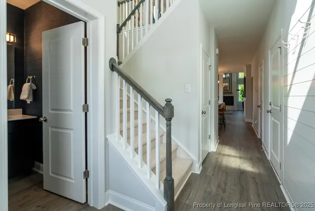 a view of staircase with lots of frames on wall and wooden floor