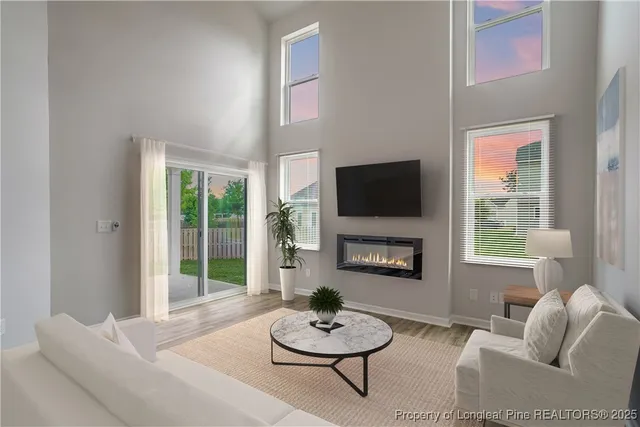 a living room with furniture a flat screen tv and a window