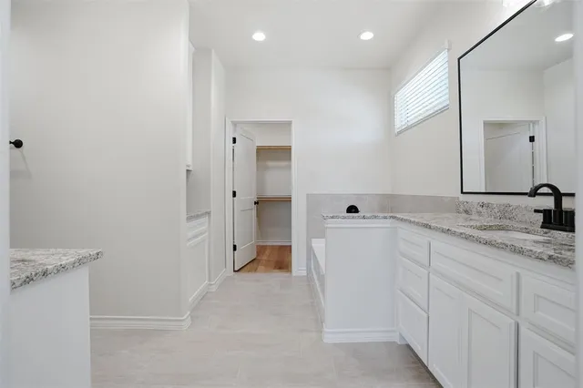 a bathroom with a granite countertop sink double and mirror