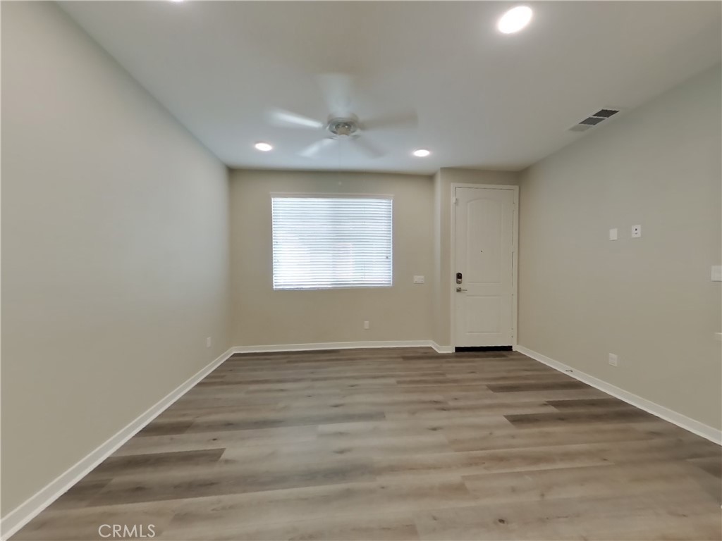 24970 Vermijo Court Wildomar, CA 92595 - Photo 2 of 28 an empty room with wooden floor and windows