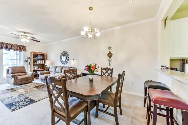 a view of a dining room with furniture and chandelier
