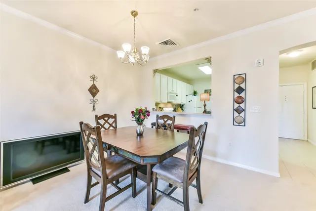 a view of a dining room with furniture and a chandelier