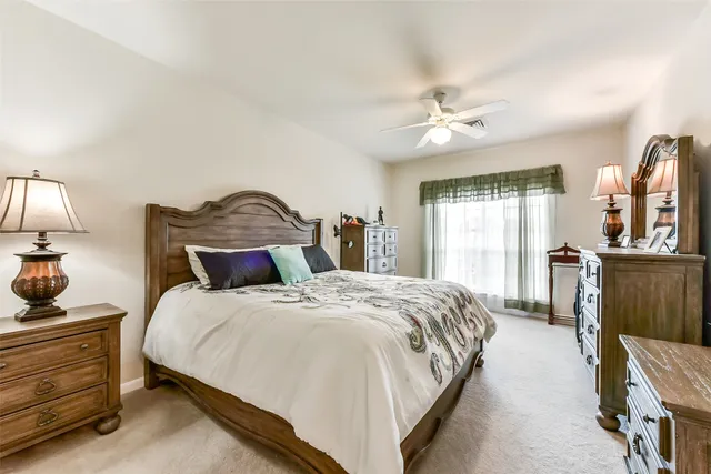 a bedroom with a large bed and a flat tv screen on dresser