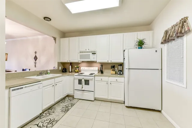 a kitchen with white cabinets appliances and sink