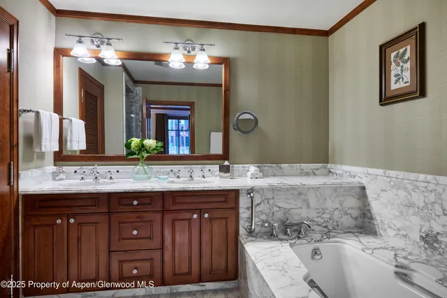 a bathroom with a granite countertop double vanity sink and a mirror