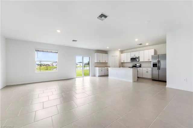 a view of a living room a kitchen with furniture and a window