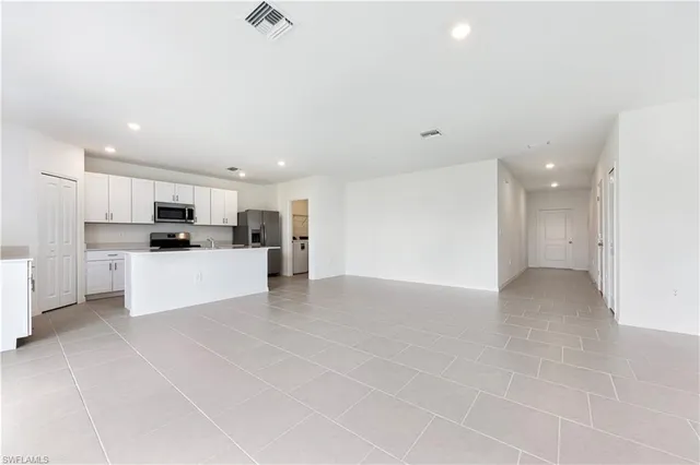 a view of kitchen with kitchen island and stainless steel appliances