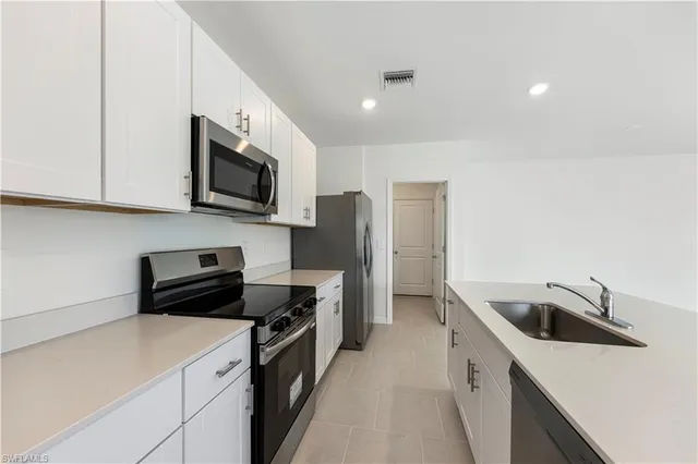 a kitchen with stainless steel appliances a stove microwave and sink