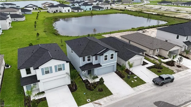 an aerial view of residential houses with outdoor space and parking