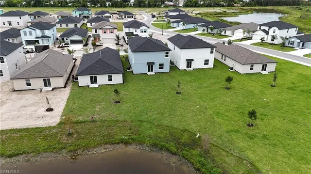 an aerial view of residential houses with outdoor space and parking