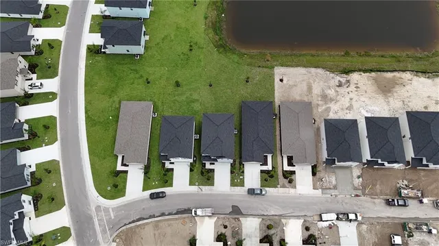 an aerial view of residential houses with outdoor space and pool