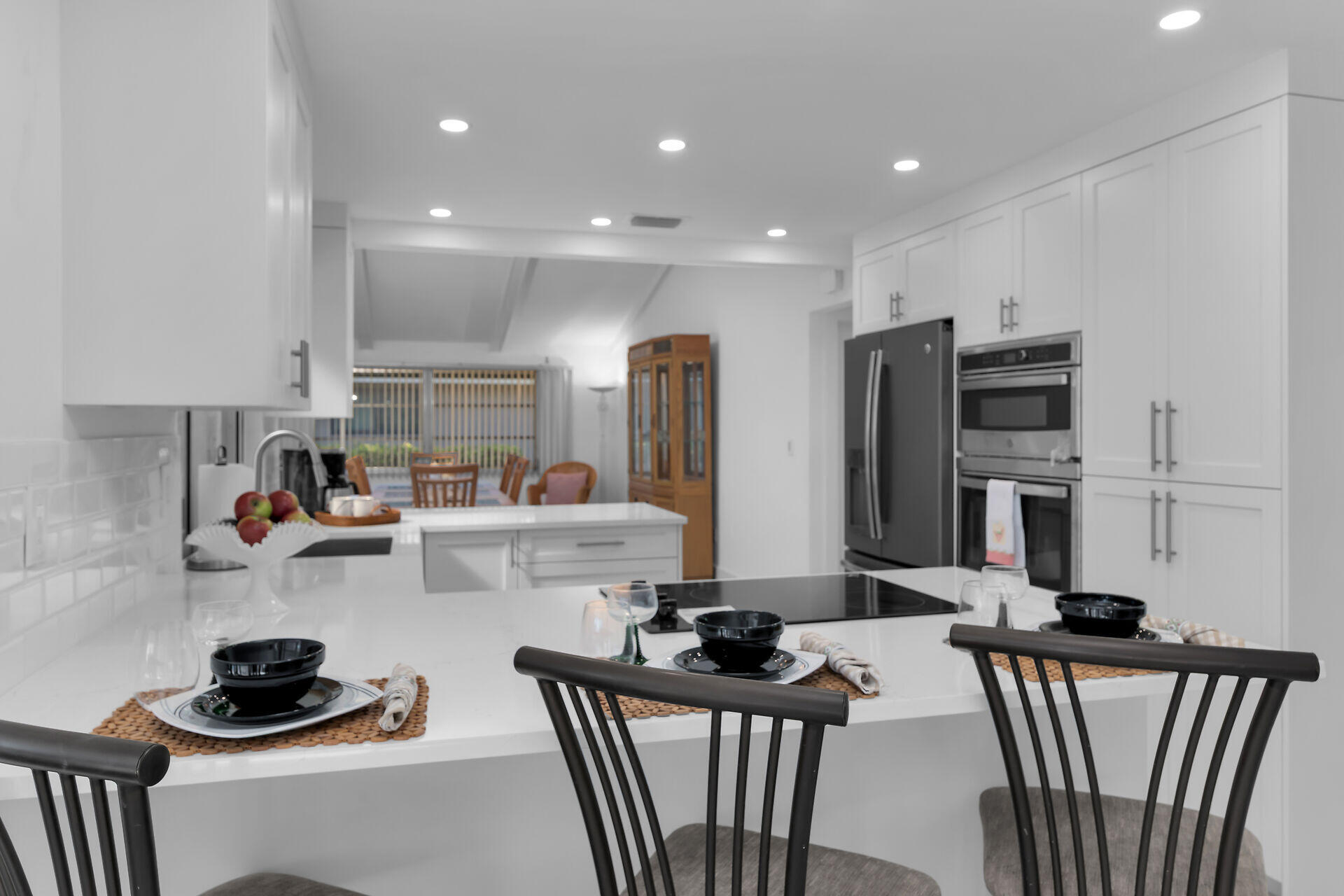 178 Torrey Pines Naples, FL 34113 - Photo 9 of 48 a kitchen with stainless steel appliances a sink a stove a refrigerator cabinets and a dining table with wooden floor