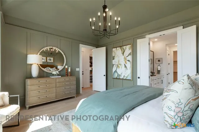 a bedroom with a bed and a chandelier