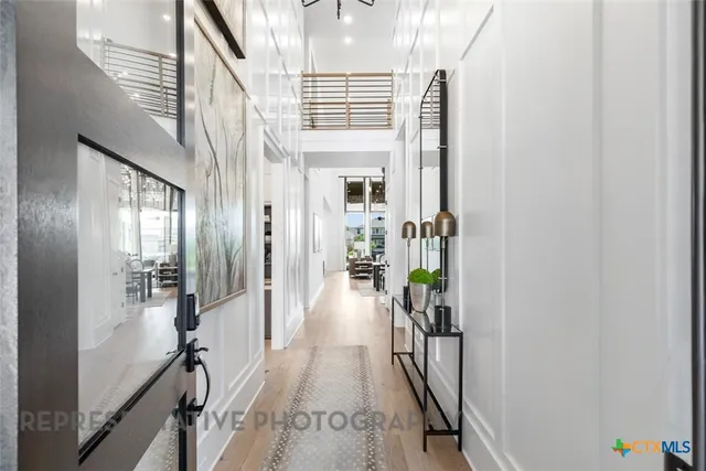 a view of a hallway with wooden floor and livingroom