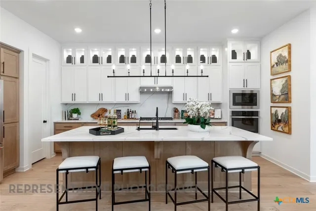 a kitchen with granite countertop white cabinets and stainless steel appliances