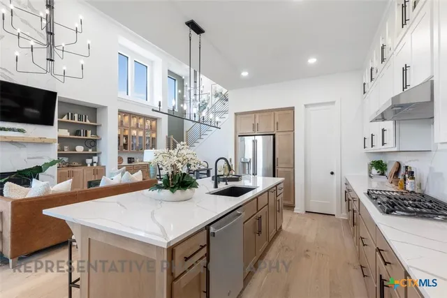 a kitchen with stainless steel appliances kitchen island granite countertop a table chairs in it and wooden floors