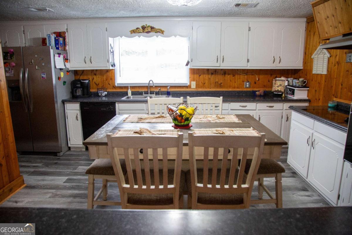 1758 Easons Bluff Road Baxley, GA 31513 - Photo 23 of 50 a kitchen with a refrigerator a stove a sink a dining table and chairs