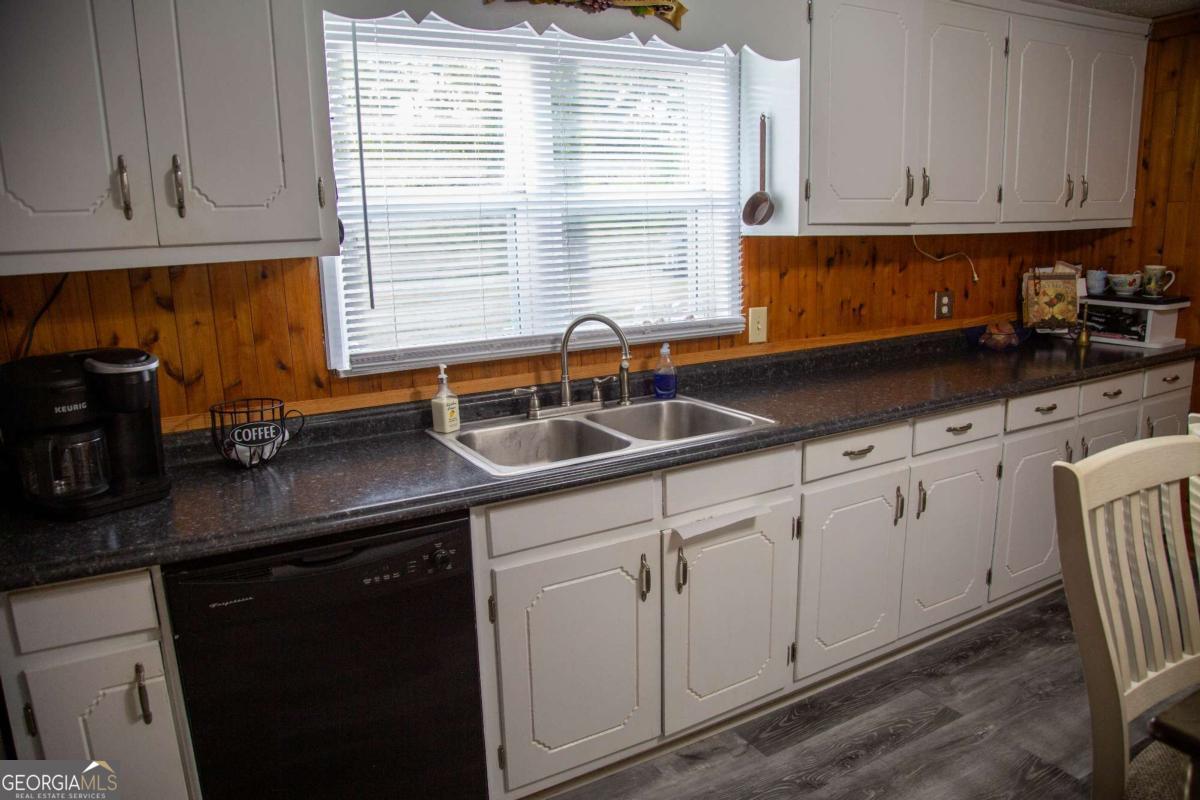 1758 Easons Bluff Road Baxley, GA 31513 - Photo 25 of 50 a kitchen with granite countertop a sink and white cabinets