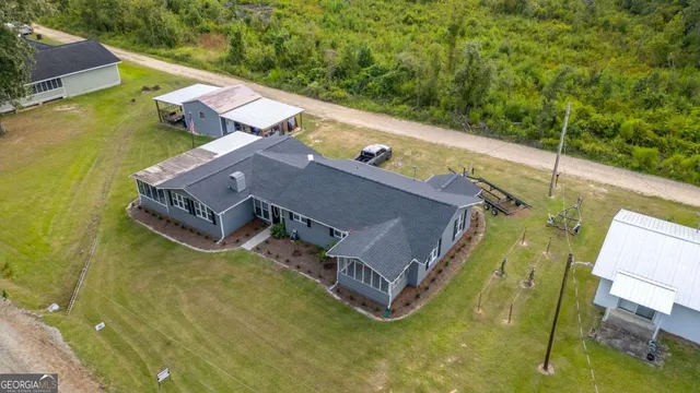 an aerial view of a house with swimming pool and large trees
