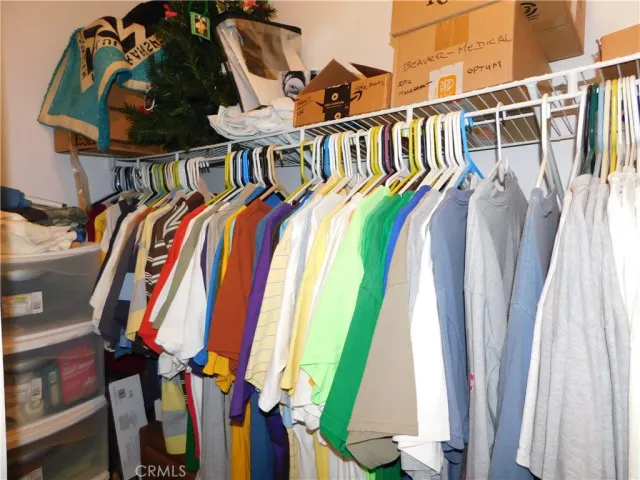 a view of walk in closet with clothes and shoes