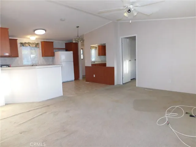 a kitchen with granite countertop a stove top oven a sink dishwasher and a refrigerator with wooden floor