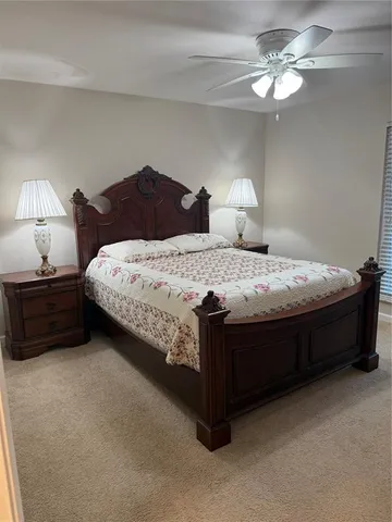 a spacious bedroom with a bed and a chandelier