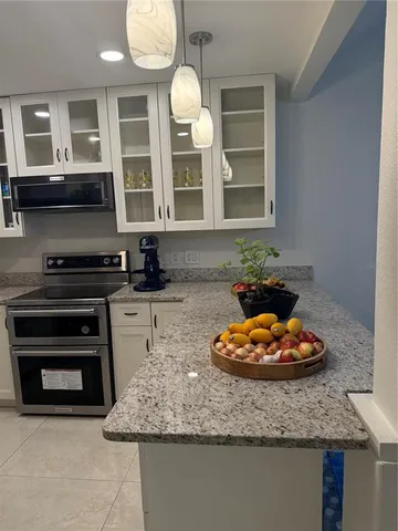 a kitchen with a sink a stove and a microwave