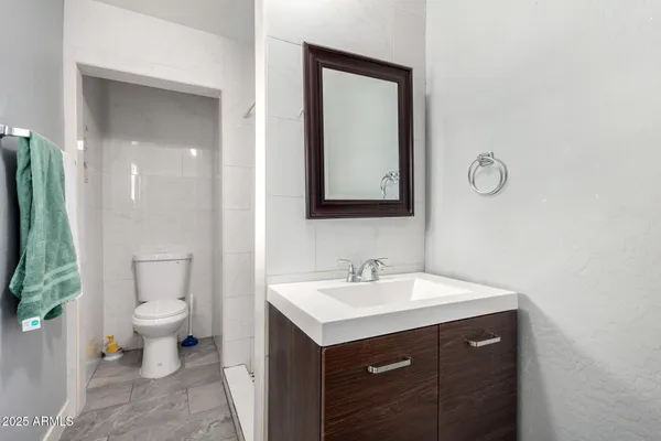 a bathroom with a toilet sink and mirror