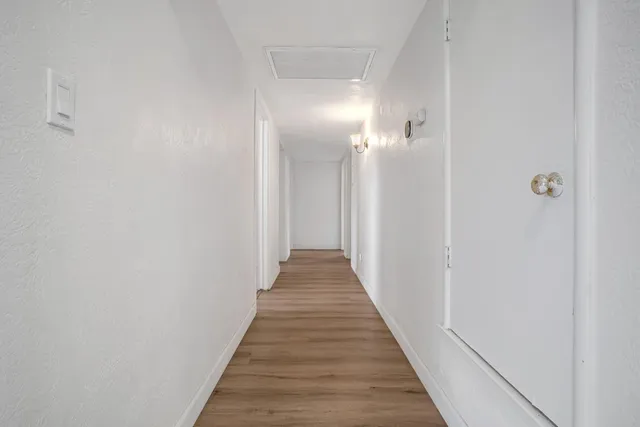 a view of a hallway with wooden floor
