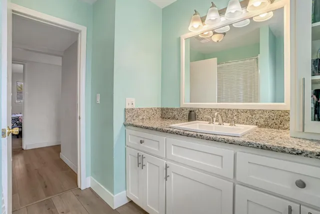 a bathroom with a granite countertop sink and a mirror