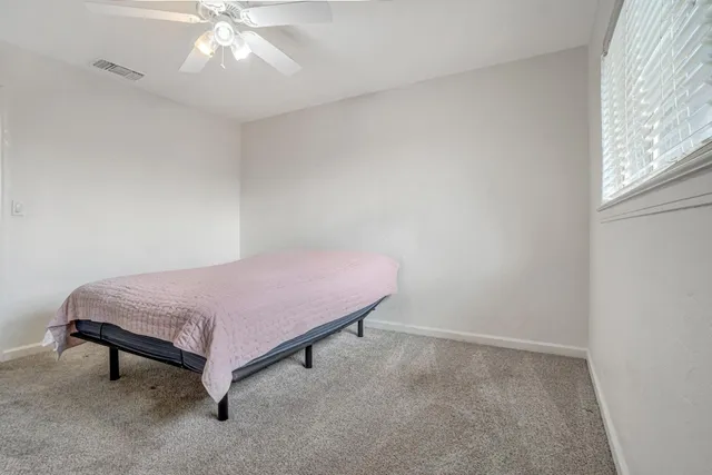 a spacious bedroom with a bed and a chandelier