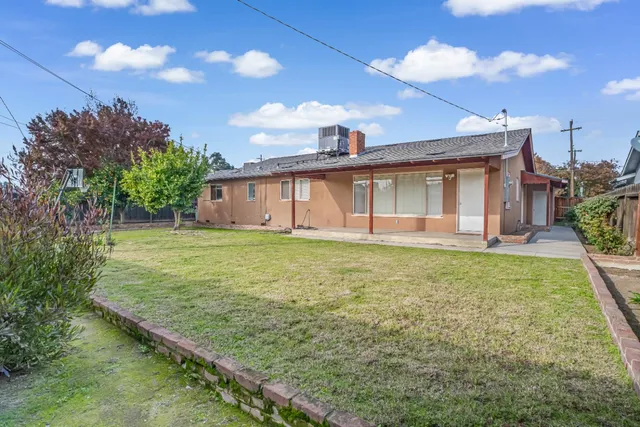 a view of a house with brick walls and a yard with plants