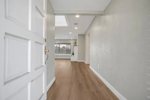 a view of a hallway with wooden floor