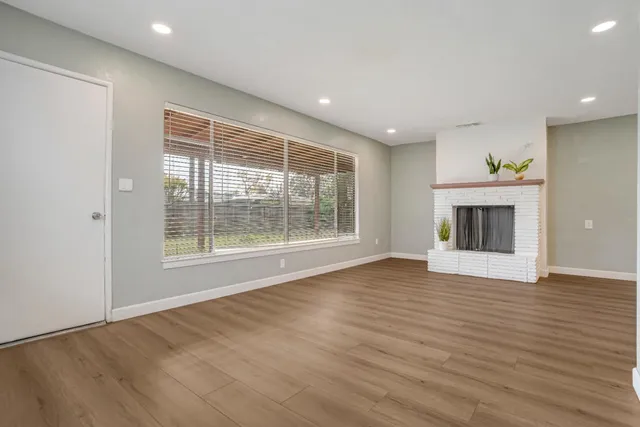 an empty room with wooden floor and a window