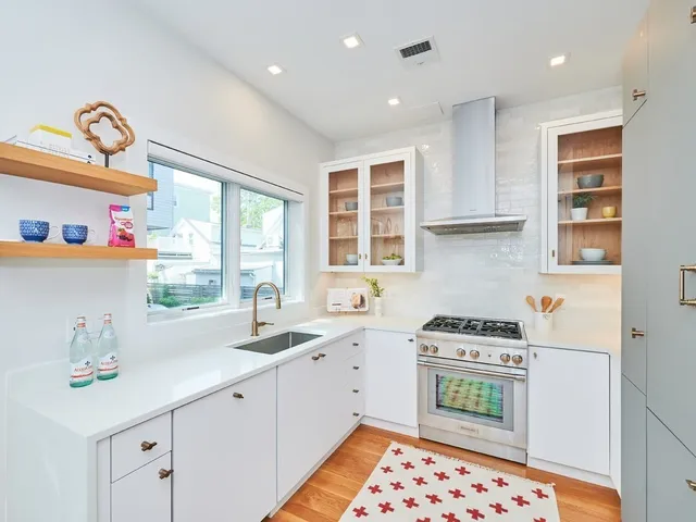 a kitchen with stainless steel appliances granite countertop a sink stove and cabinets
