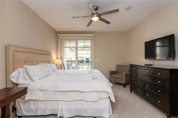 a bedroom with a bed a window and a flat screen television