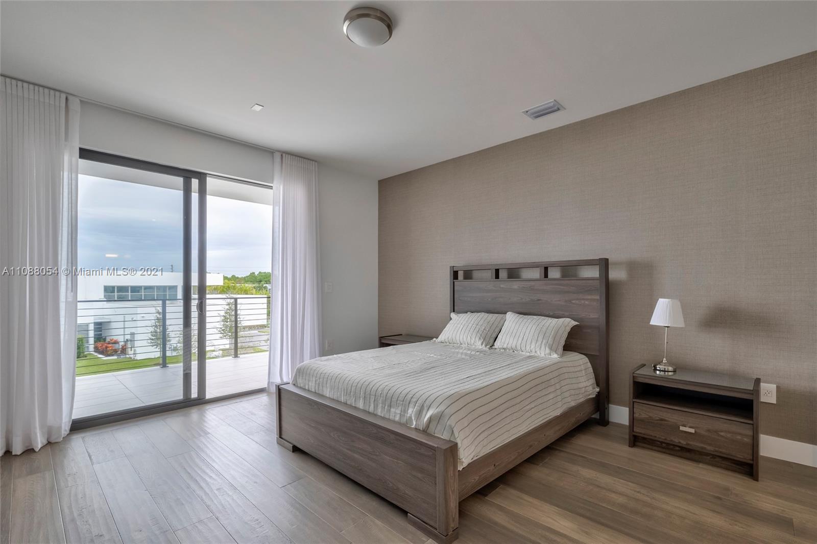 16610 Sunset Way Weston, FL 33326 - Photo 24 of 35 a bedroom with a large bed and a large window