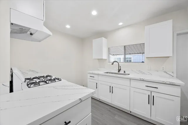 a kitchen with white cabinets and appliances