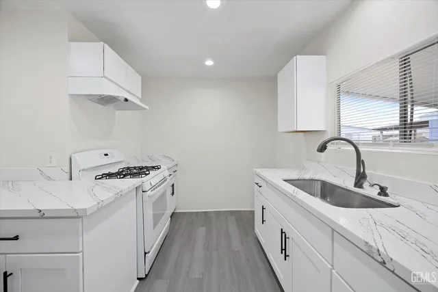 a kitchen with stainless steel appliances granite countertop a sink and a stove top oven