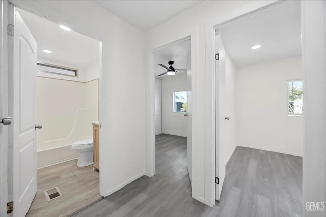 an empty room with windows and fan