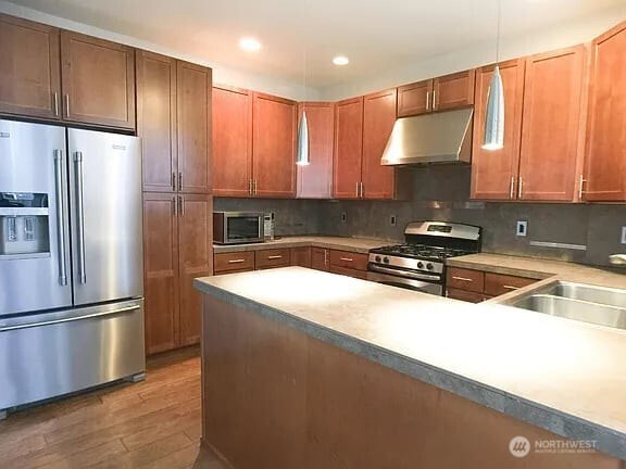 1329 159th Street Southwest Lynnwood, WA 98087 - Photo 4 of 10 a kitchen with a refrigerator a sink a stove and cabinets