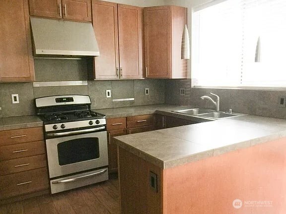 1329 159th Street Southwest Lynnwood, WA 98087 - Photo 5 of 10 a kitchen with granite countertop a sink a stove and microwave