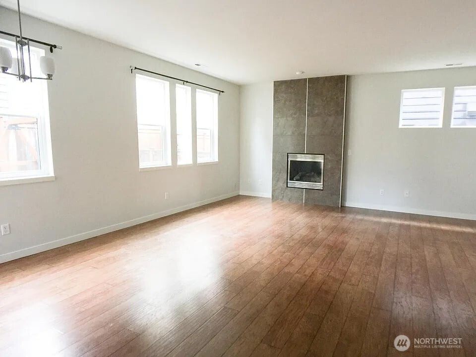 1329 159th Street Southwest Lynnwood, WA 98087 - Photo 6 of 10 an empty room with windows and a fireplace